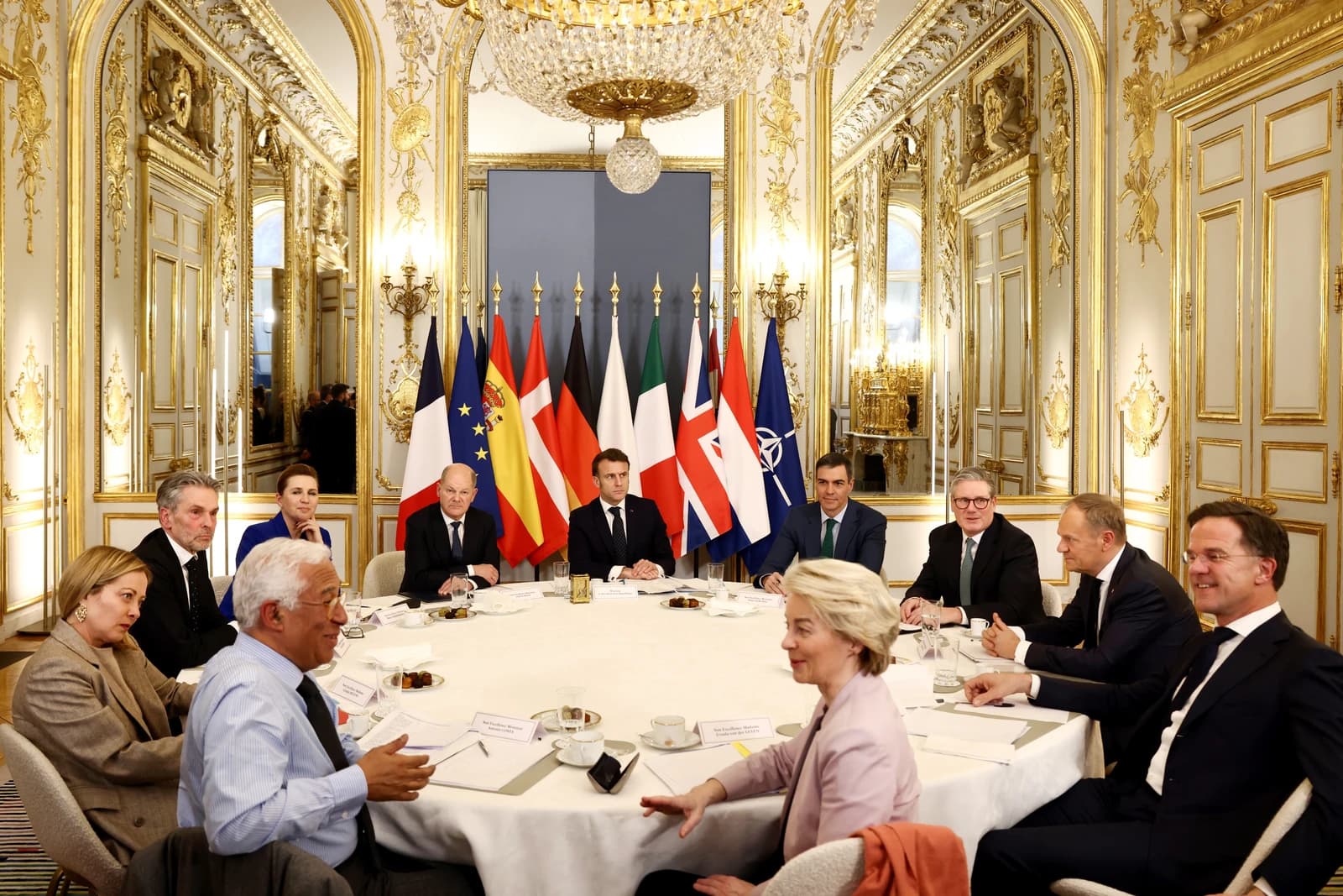 European leaders including Macron, Scholz, von der Leyen, and Sanchez at a conference in Paris.