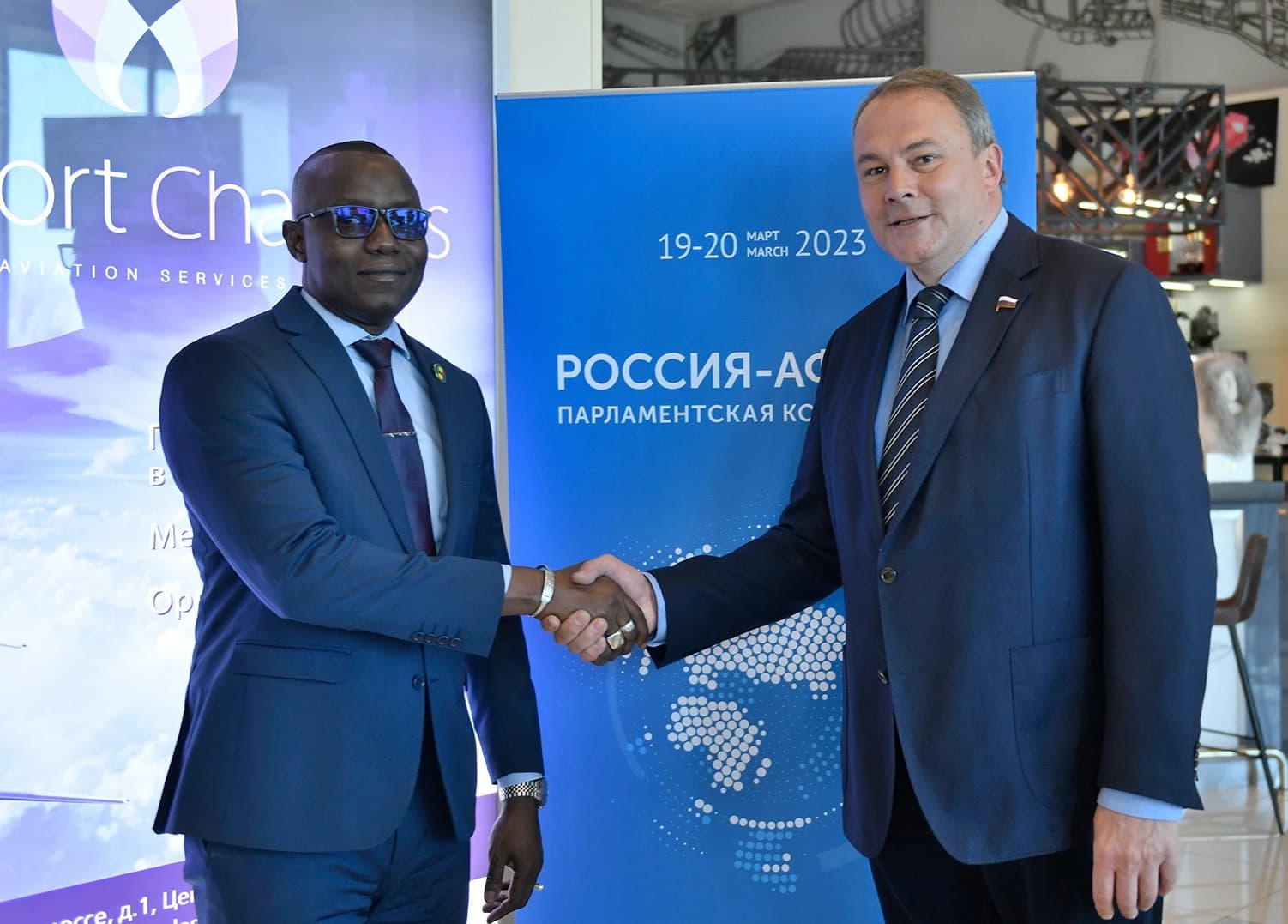 Petr Tolstoy, Duma Vice President, shaking hands with Malick Diaw at an event.