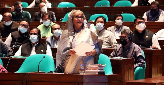Prime Minister Sheikh Hasina speaking at a microphone in the National Parliament.