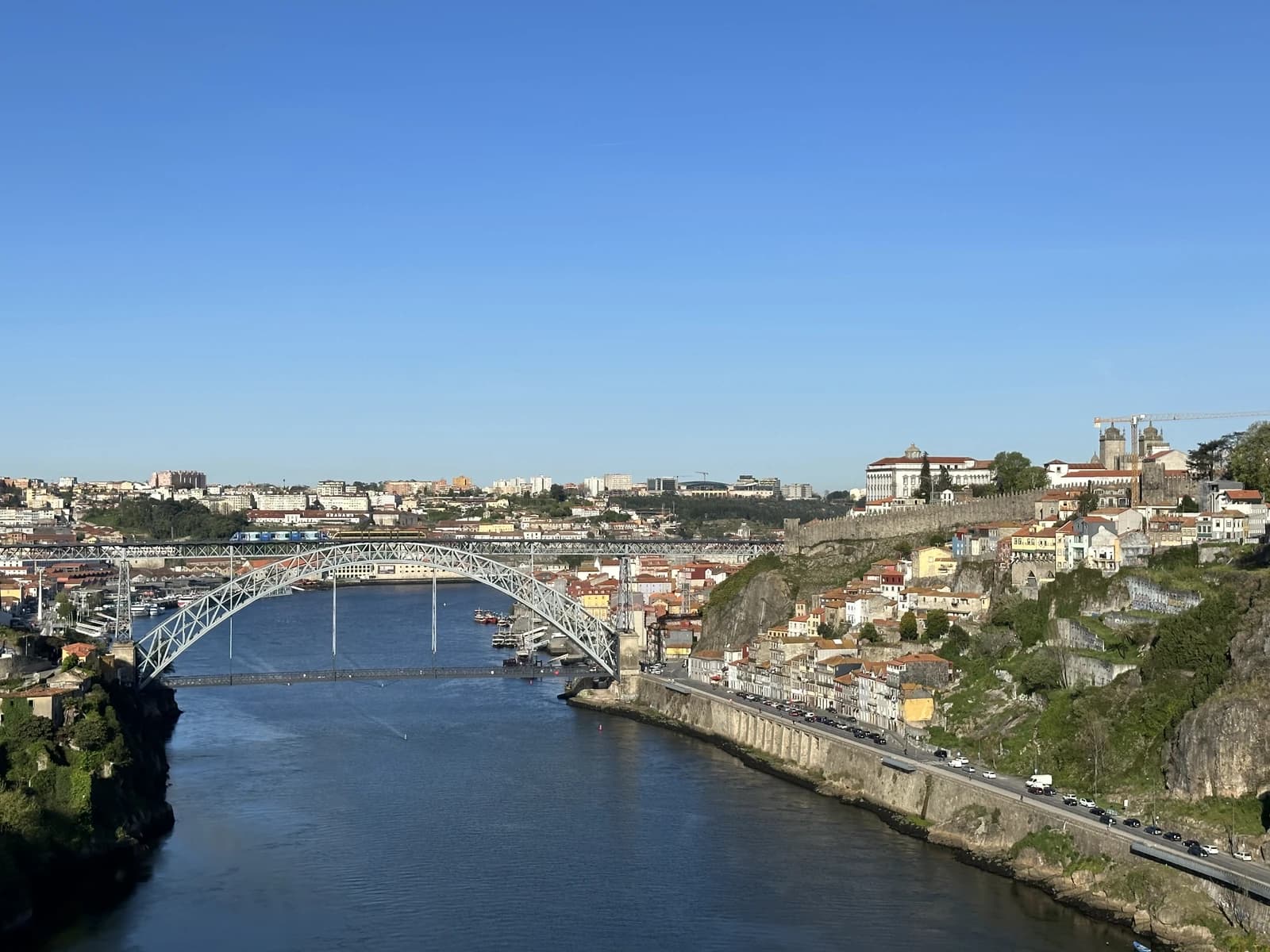 Dom Luís I Bridge spanning the Douro River in Porto, Portugal, with cityscape on hills.