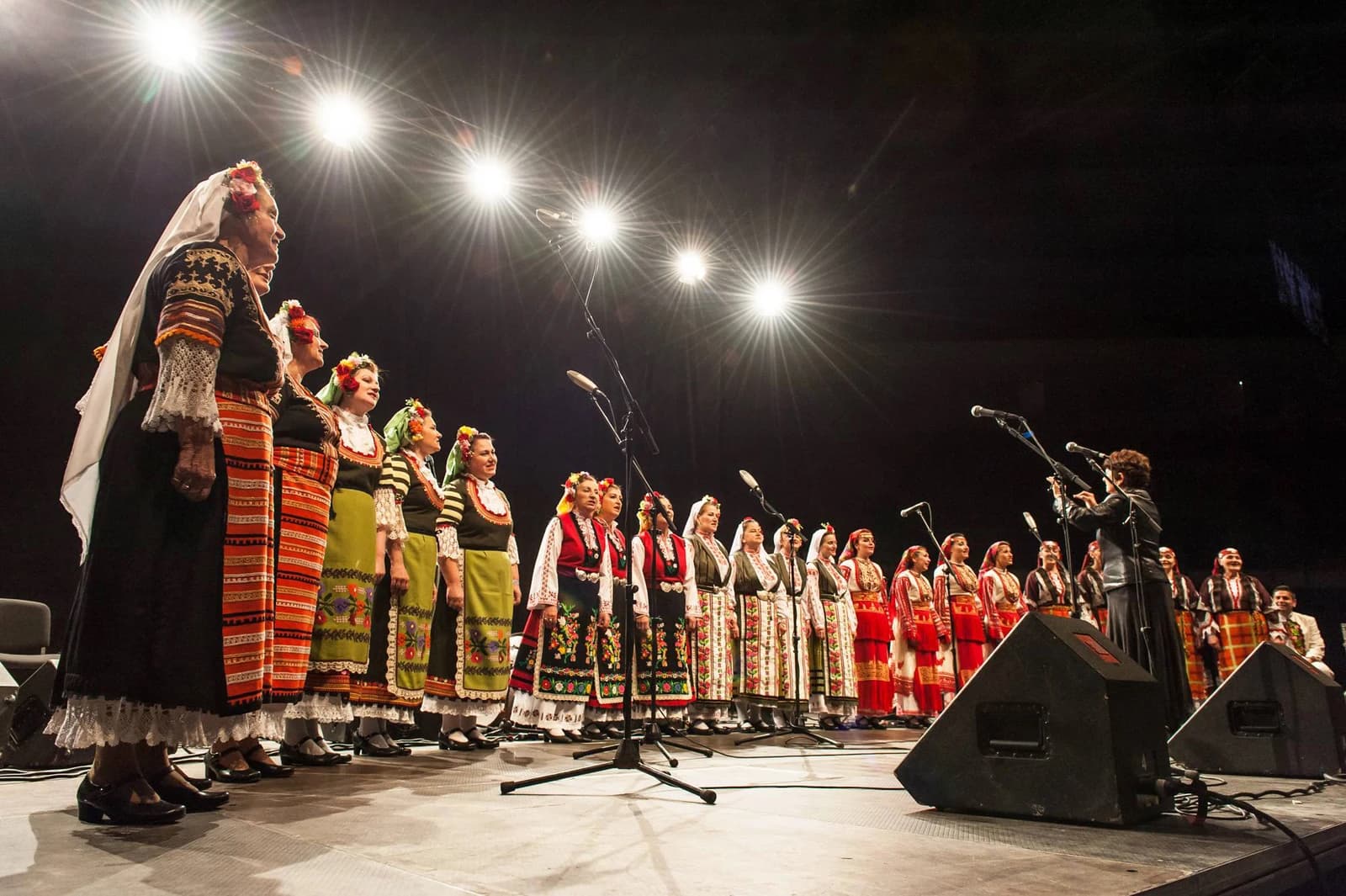 Female choir, known as The Mystery of Bulgarian Voices, performing on stage.