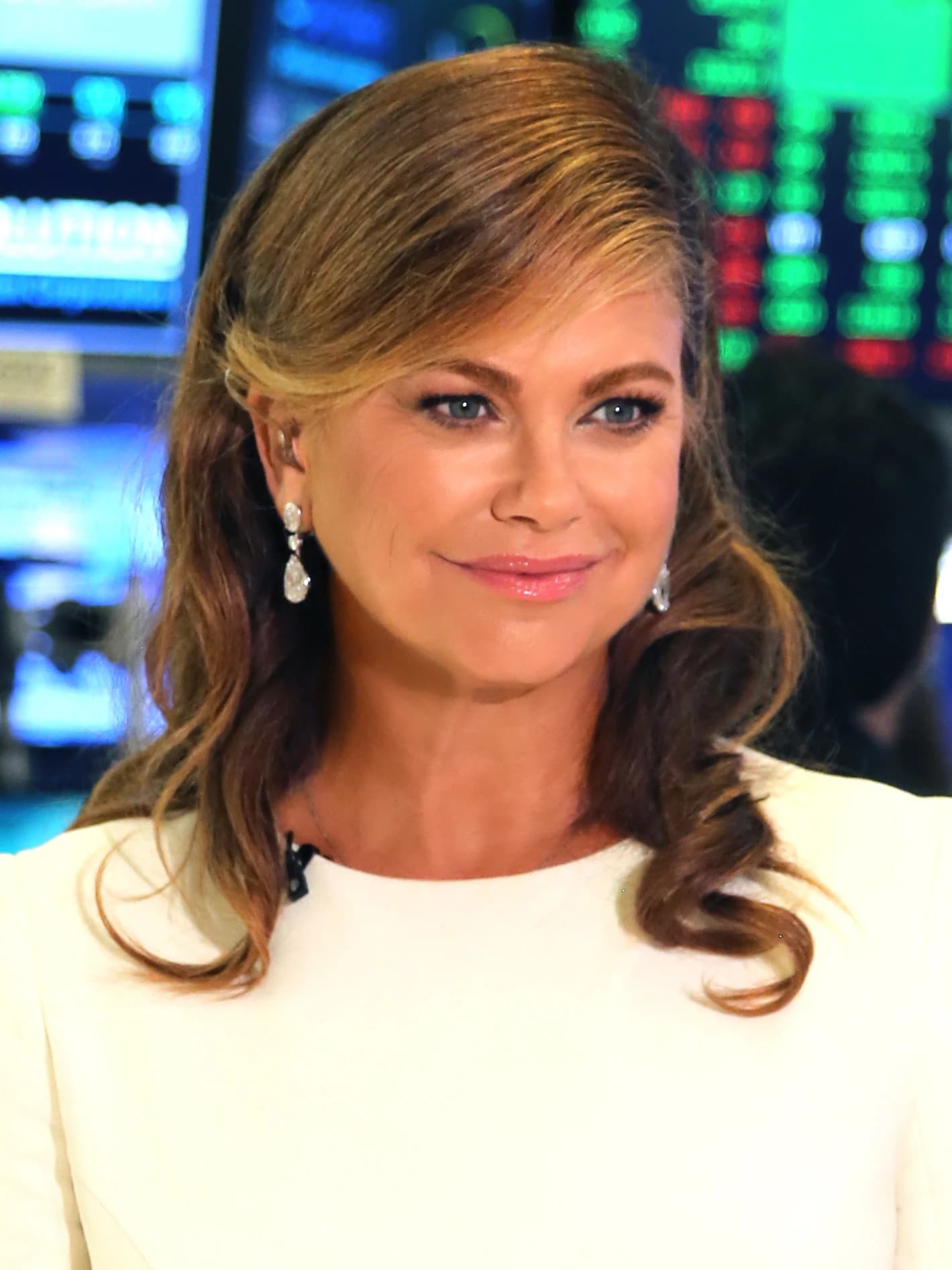 Kathy, with long hair and earrings, at the New York Stock Exchange.