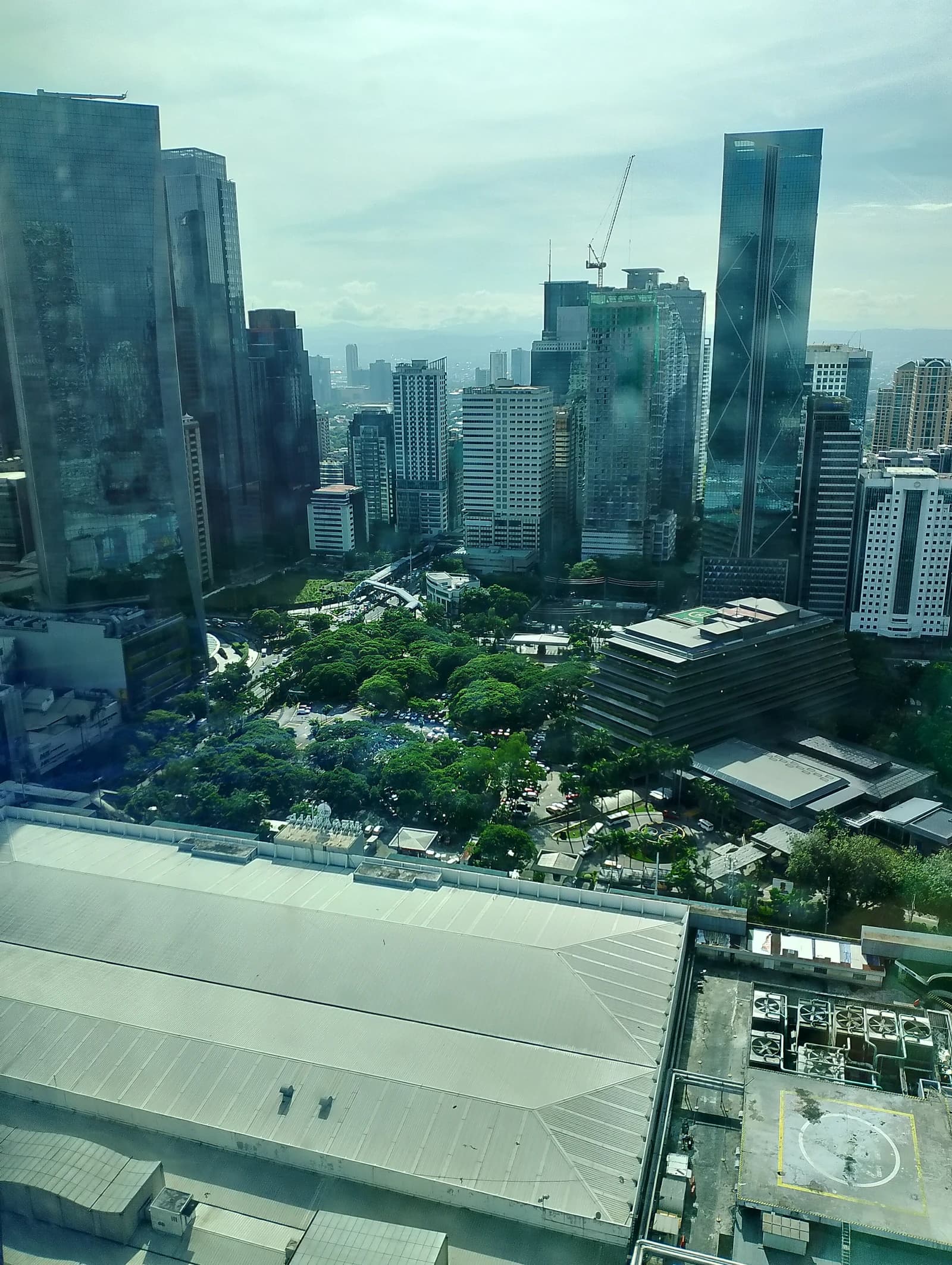 Ortigas Center skyline in Manila, Philippines, showing tall modern buildings and a park area.