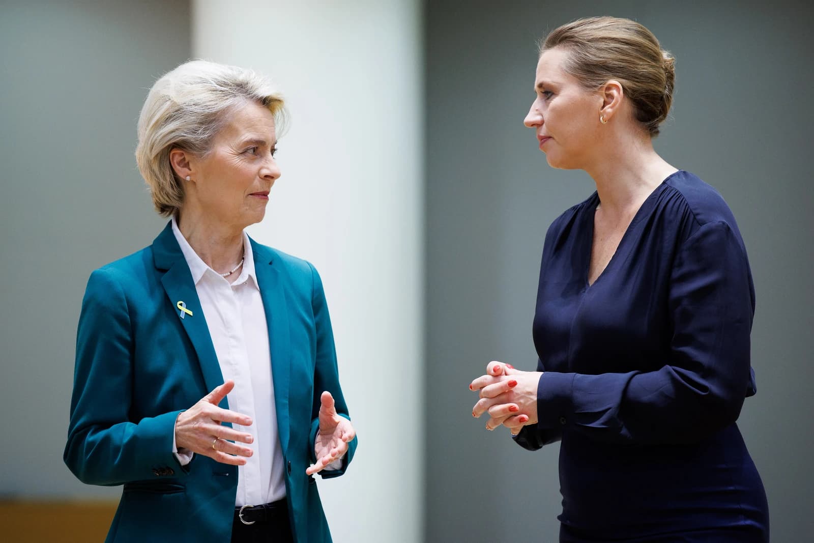 Ursula von der Leyen and Mette Frederiksen engaged in a discussion during an event.