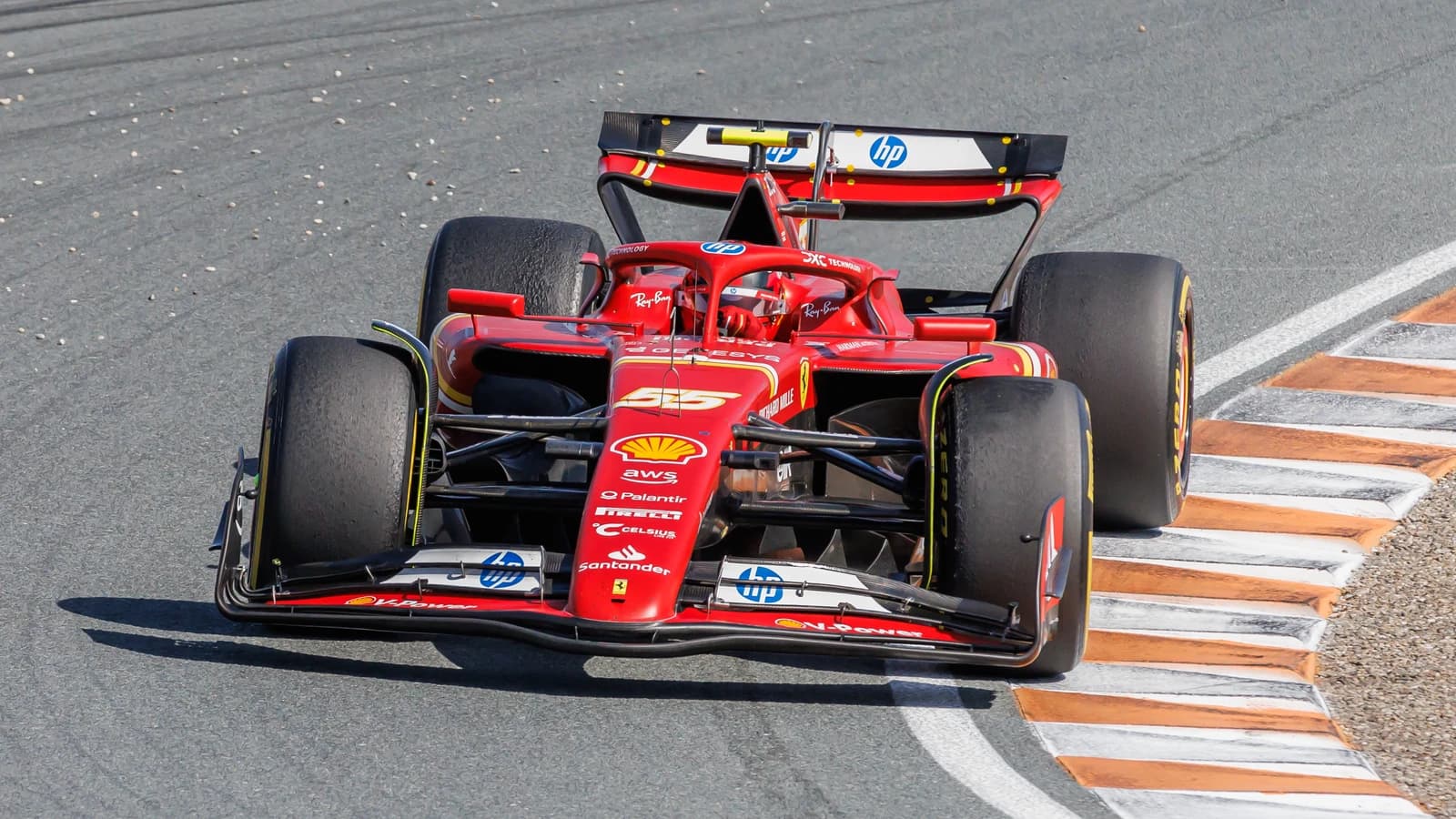 Red Ferrari Formula 1 car on a race track during a Grand Prix event.