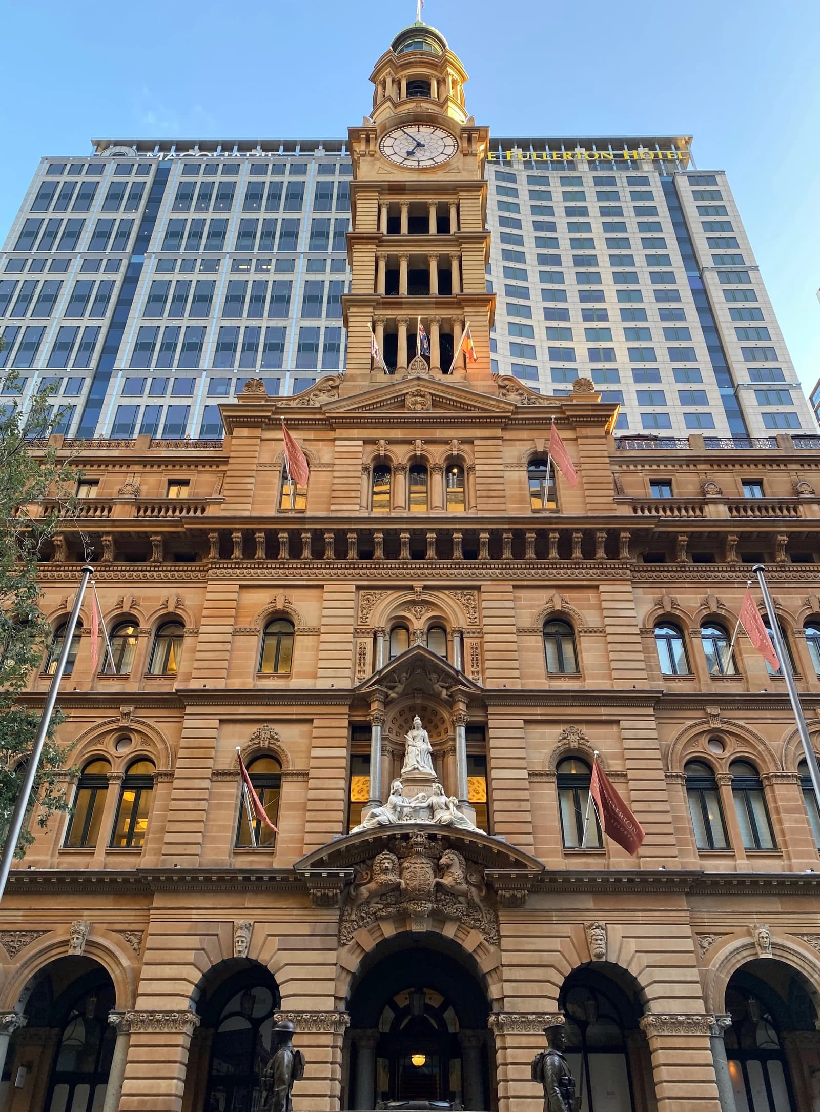 Clock tower on Martin Place building in Sydney, with modern office tower behind.