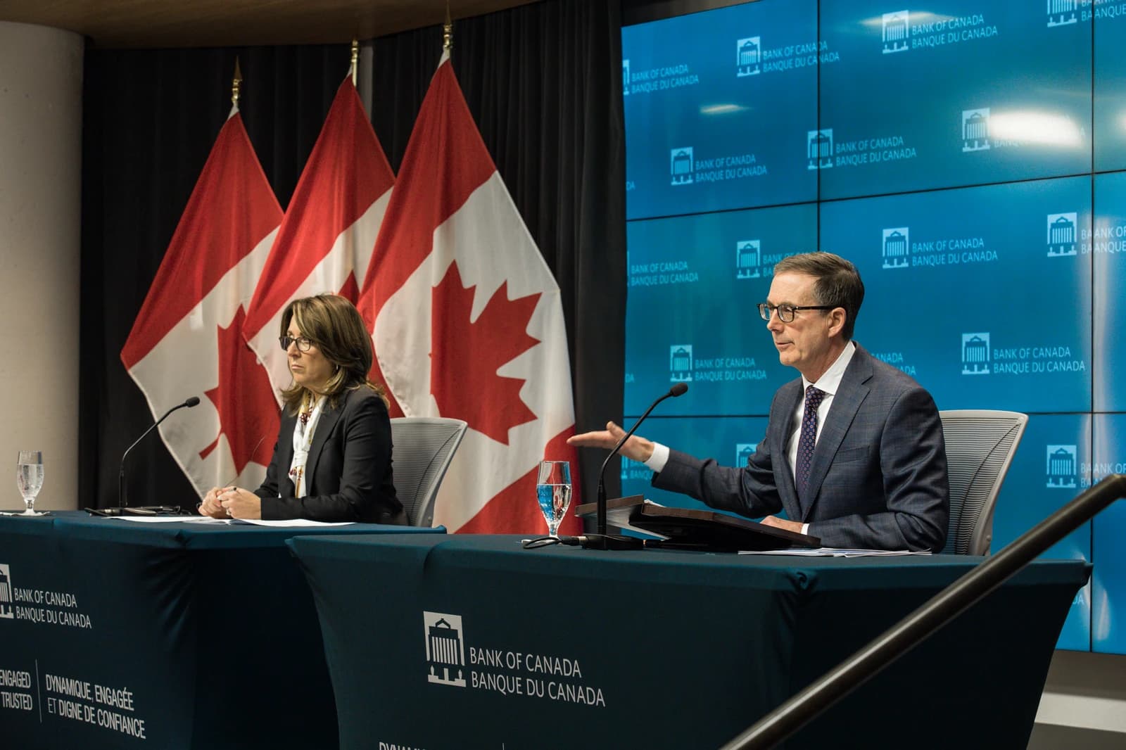 Bank of Canada Governor Tiff Macklem speaks with Carolyn Rogers seated beside him.