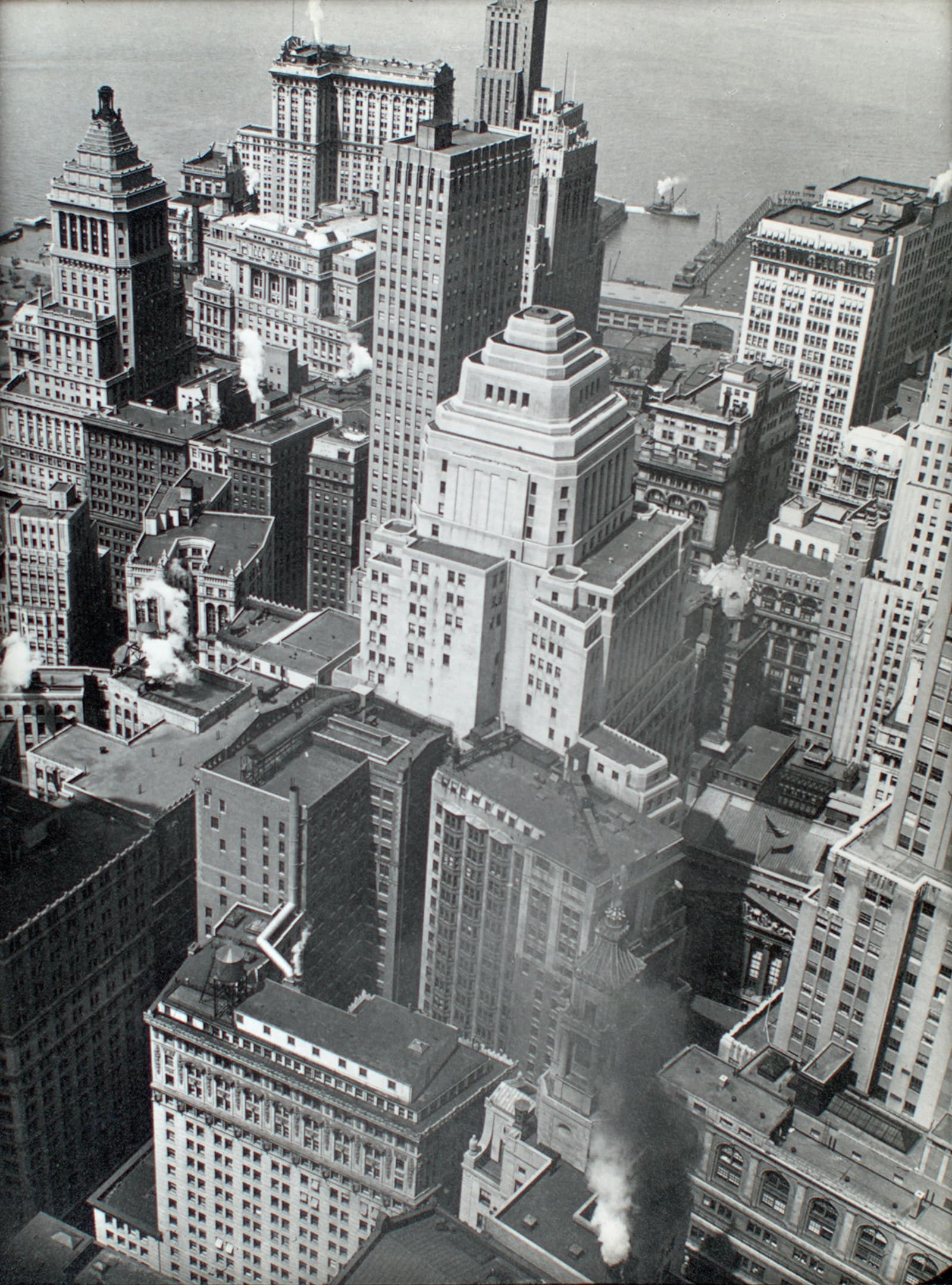 Aerial view of financial district rooftops, Manhattan, with steam plumes.