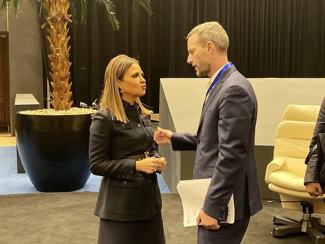 Sahar Nasr speaks with Adam Boehler at a conference event.