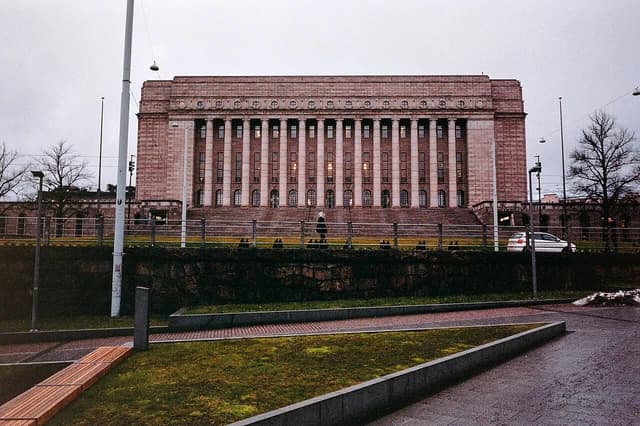 Parliament House, a large stone building with many columns, in Helsinki, Finland.