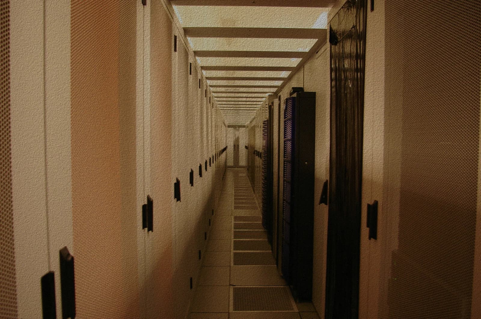 An empty corridor inside a data center lined with server racks.