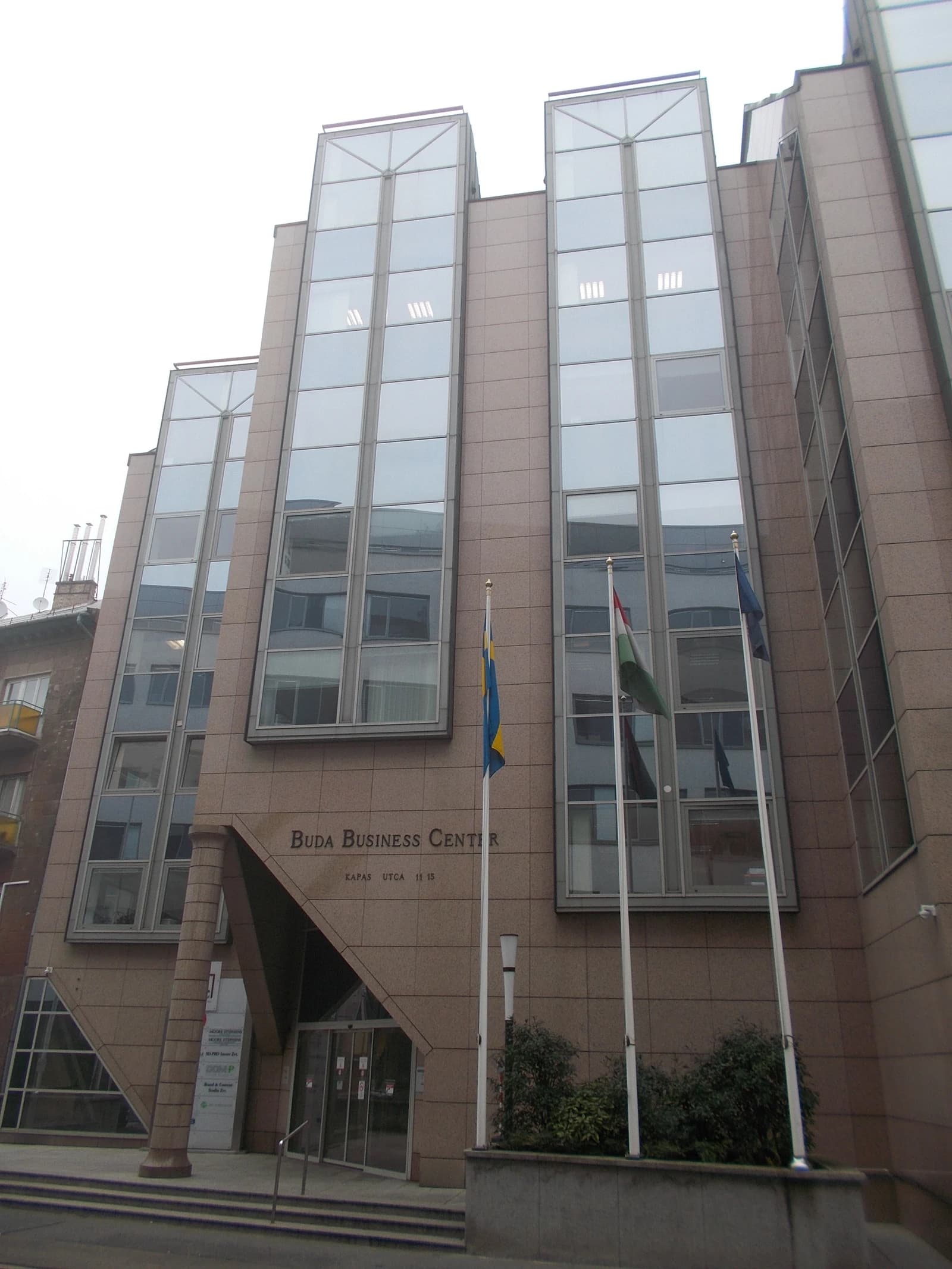 Buda Business Center building in Budapest with reflective glass windows and flags.