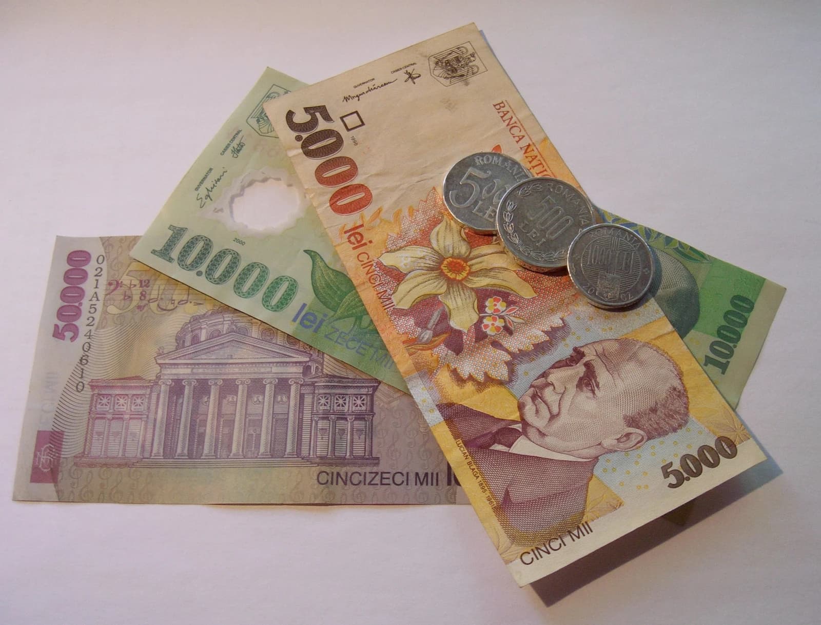 Several Romanian Lei banknotes and coins displayed together on a white background.