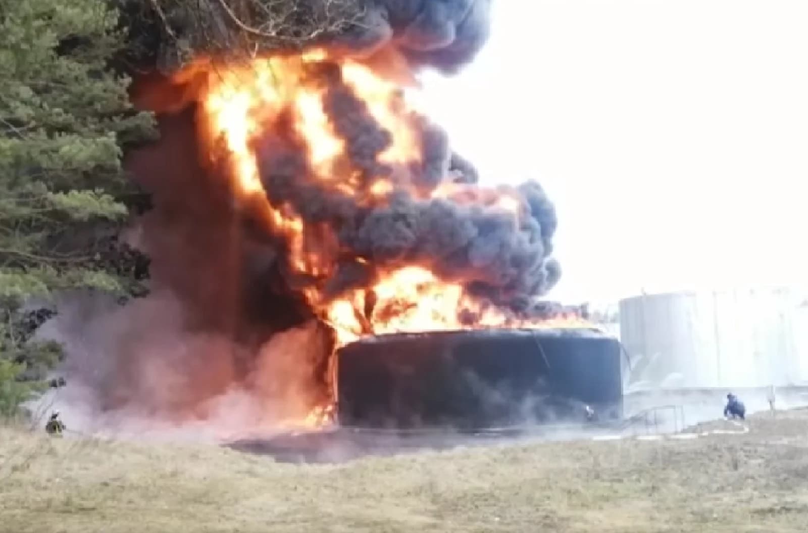 Ukrainian firefighters battling large flames and thick smoke from diesel fuel tanks.