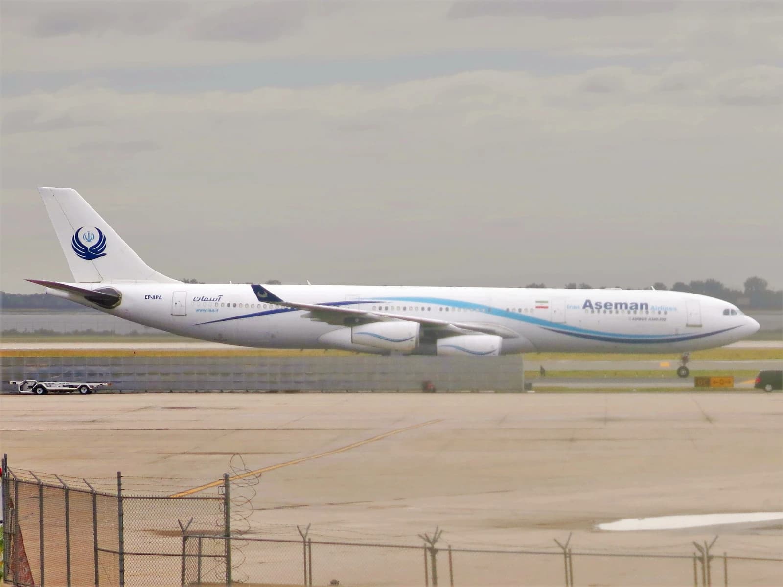 Iran Aseman Airlines Airbus A340-311 aircraft parked on an airport tarmac.
