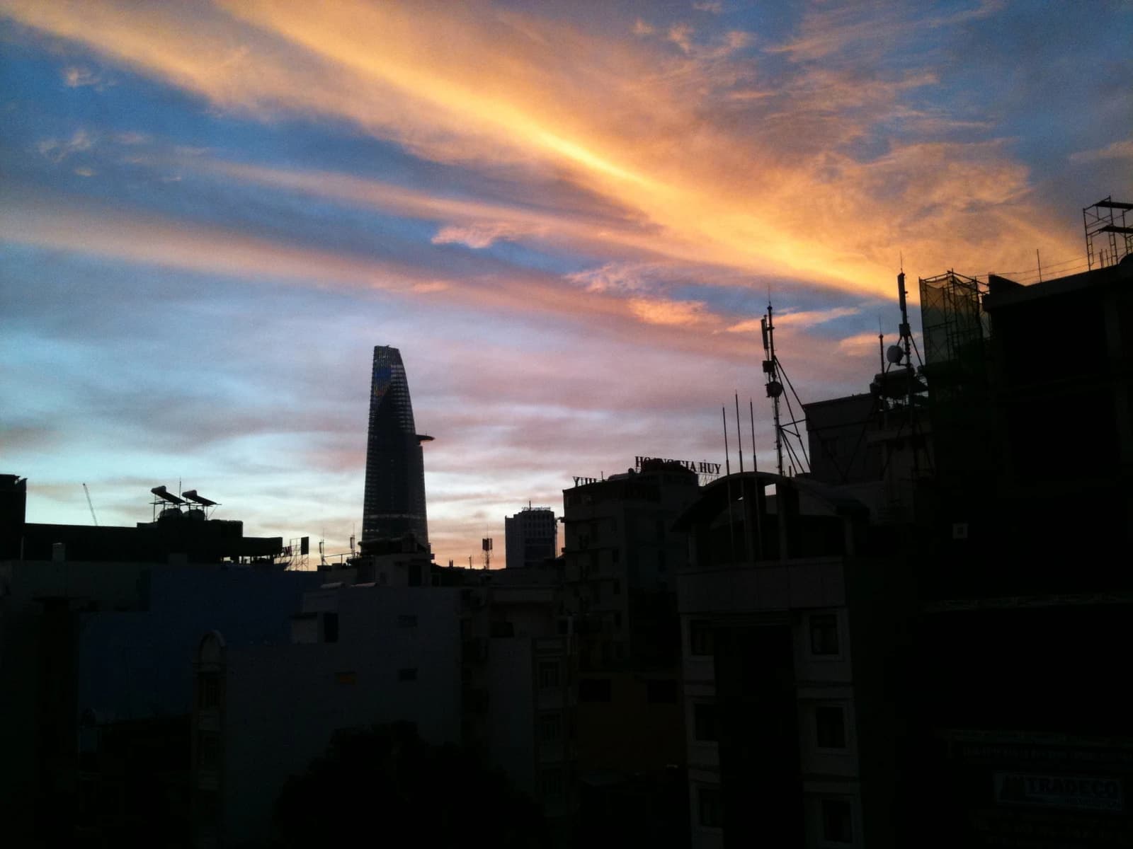 Ho Chi Minh City skyline at sunrise with the Bitexco Financial Tower prominent.