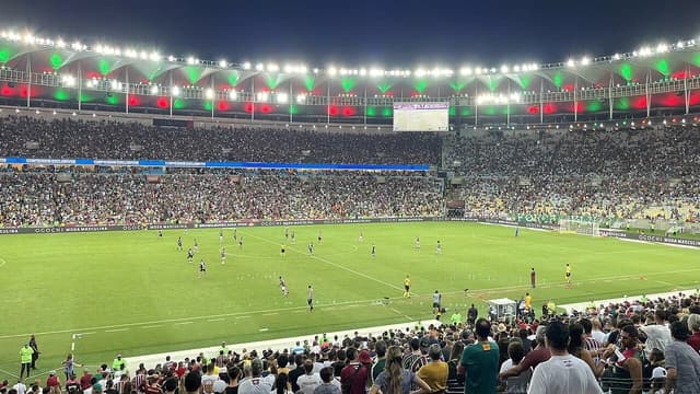 Soccer match in progress at Maracanã Stadium with a large crowd in the stands.