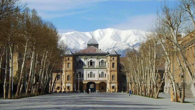 Building at the Compounds of the Foreign Ministry of Iran in Tehran, with snow-capped mountains behind.