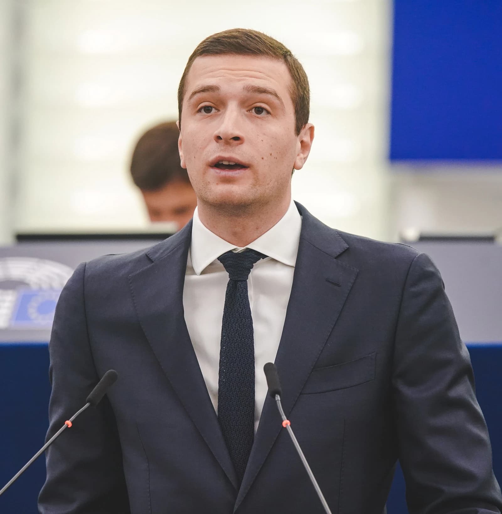 Jordan Bardella, French far-right politician, speaking at a podium.