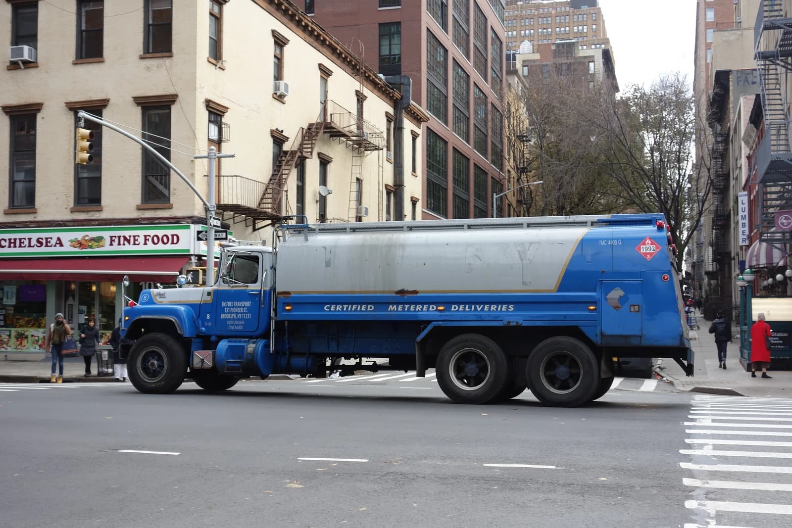 A blue and silver fuel tanker truck parked on a city street.