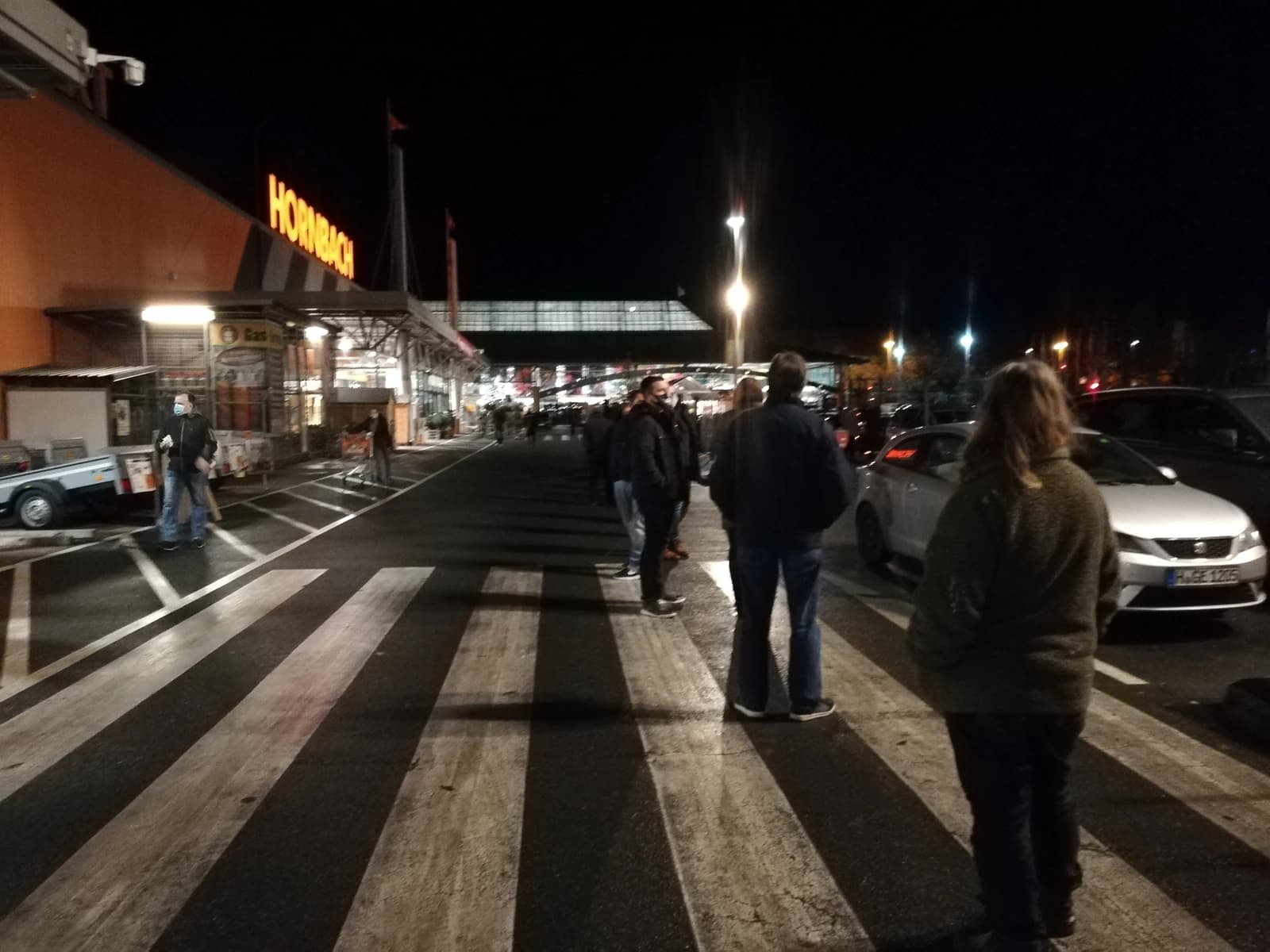 People queuing outside a Hornbach hardware store at night in December 2020.
