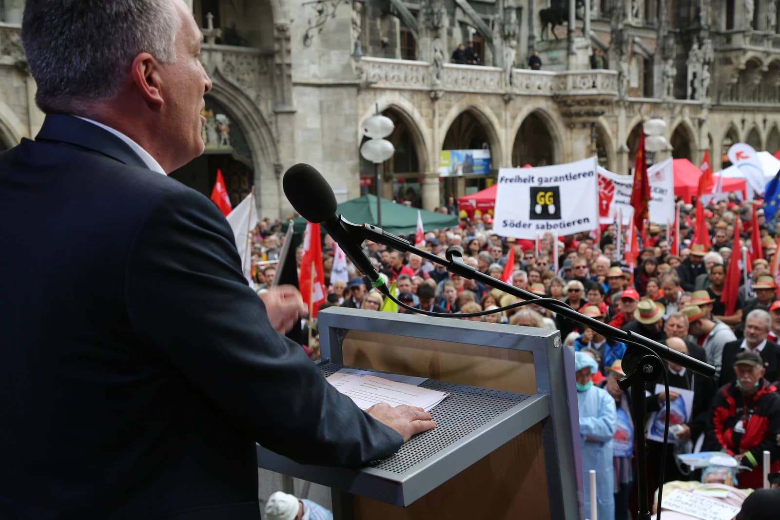 Jürgen Kerner, a representative of IG Metall, speaking at an outdoor rally in front of a crowd.