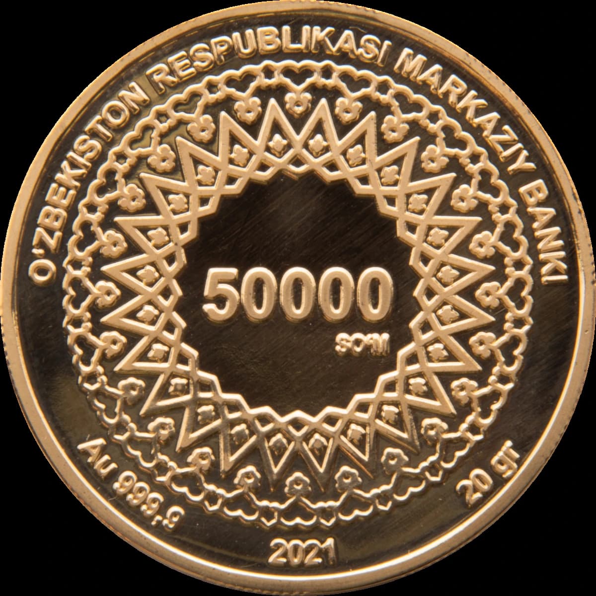 Close-up of a 2021 gold coin from the Central Bank of Uzbekistan, showing '50000 som' and 'Au 999.9'.