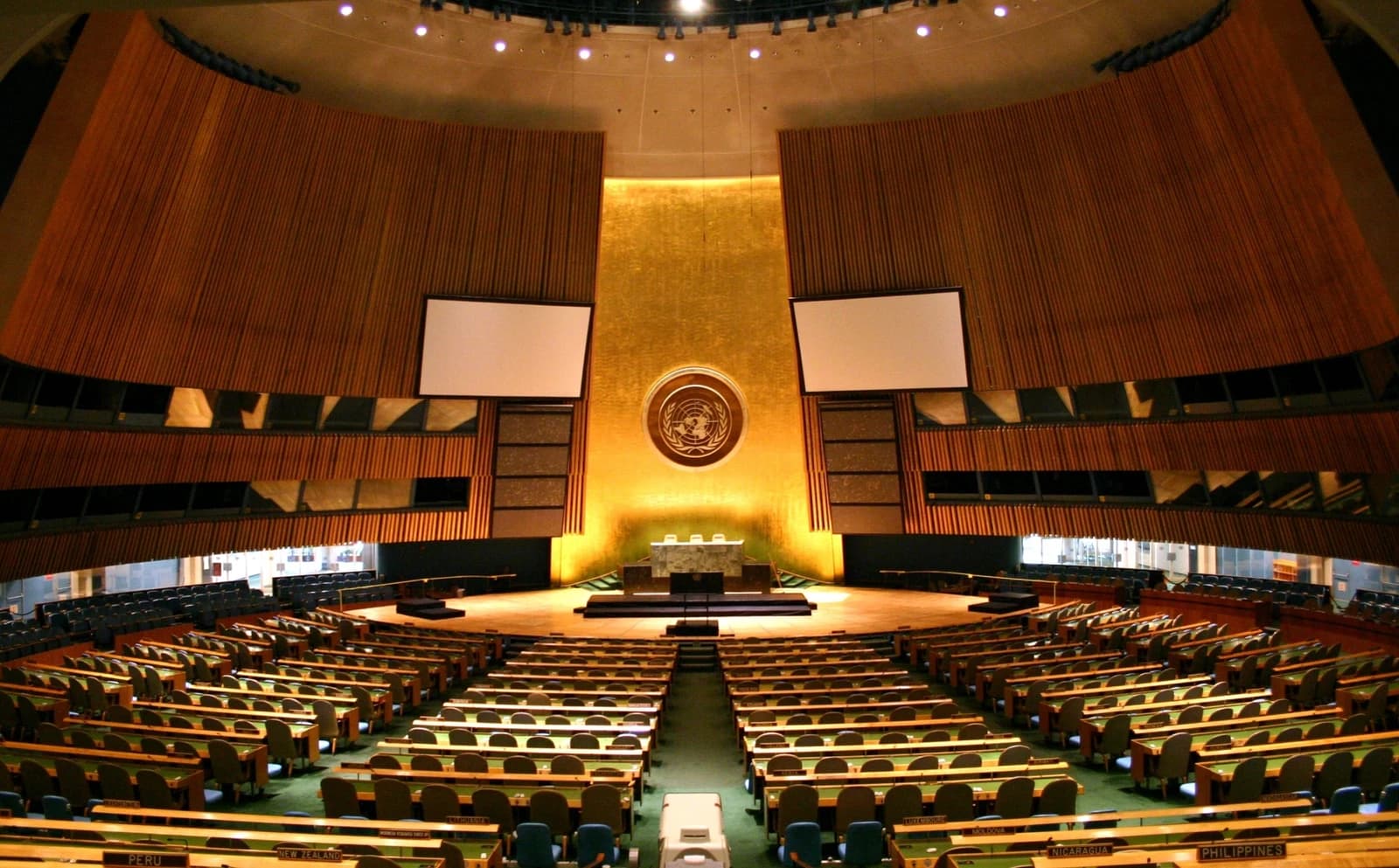 Empty United Nations General Assembly Hall with seating for delegates.