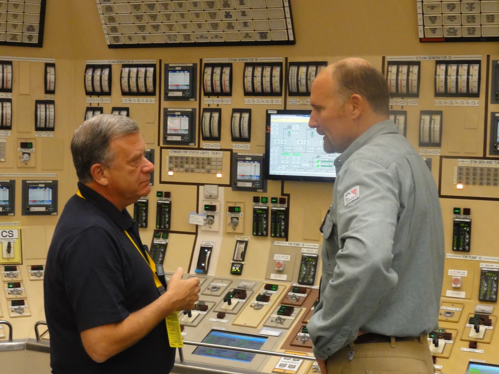 NRC Commissioner Wright speaking with a plant employee inside a nuclear power plant control room.