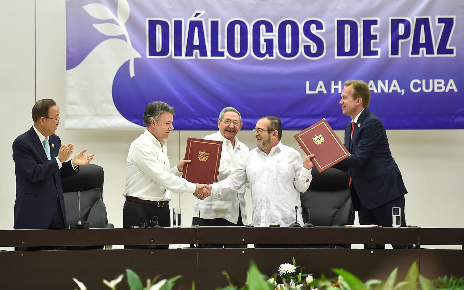 Colombian President Juan Manuel Santos and FARC leader Timochenko shaking hands after signing peace accords.