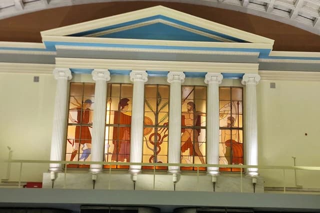 Stained glass windows depicting classical figures inside the old Athens Stock Exchange.