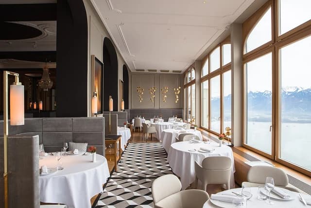 Restaurant dining room at Glion Institute, with formal place settings and mountain views.