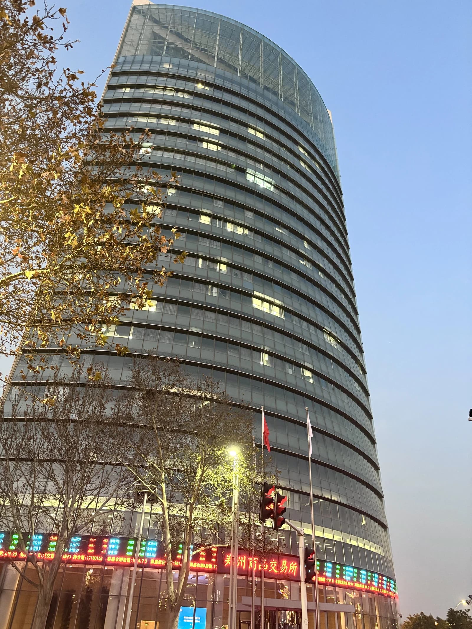 Zhengzhou Commodity Exchange building exterior at dusk with visible stock ticker information.