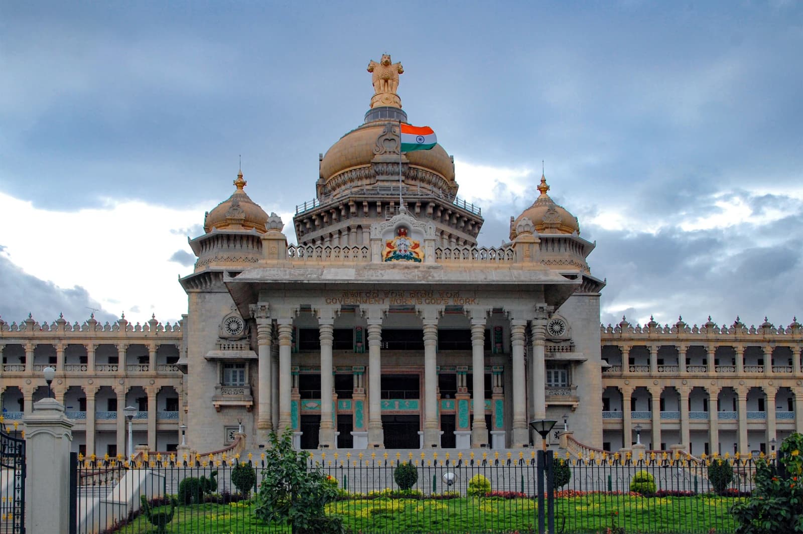 Exterior shot of Vidhana Soudha, a large stone government building with domes and columns.