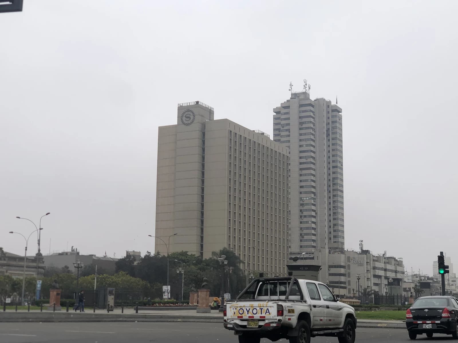 Sheraton Hotel and Centro Cívico buildings in Lima, Peru, with traffic in foreground.