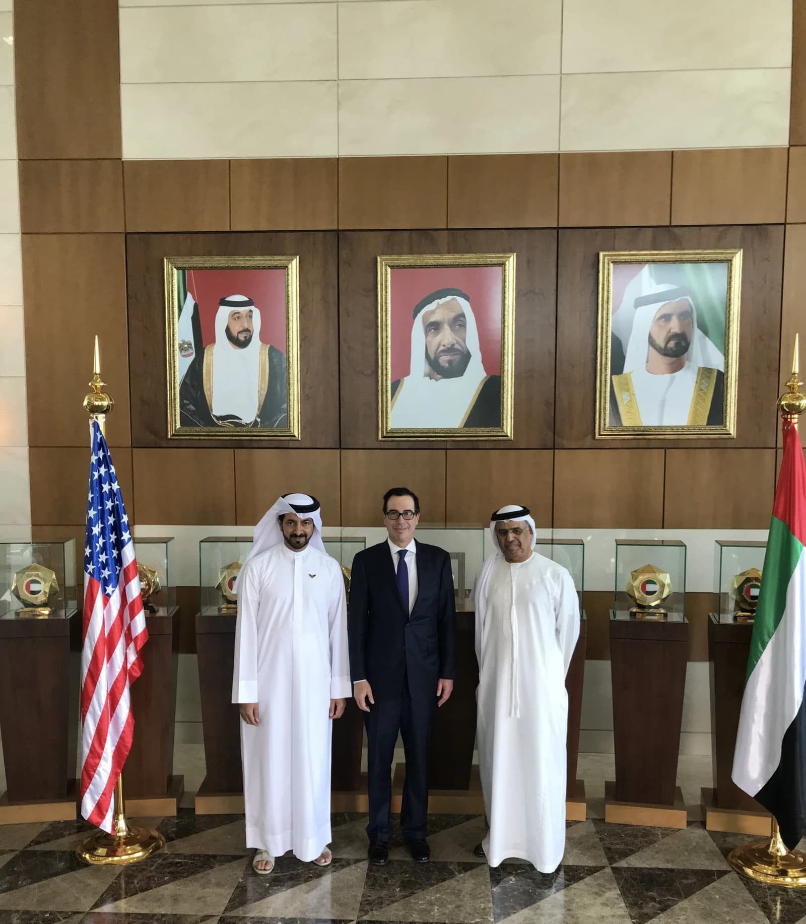 Steven Mnuchin, Obaid Humaid Al Tayer, and Mubarak Rashed Al-Mansoori stand indoors.