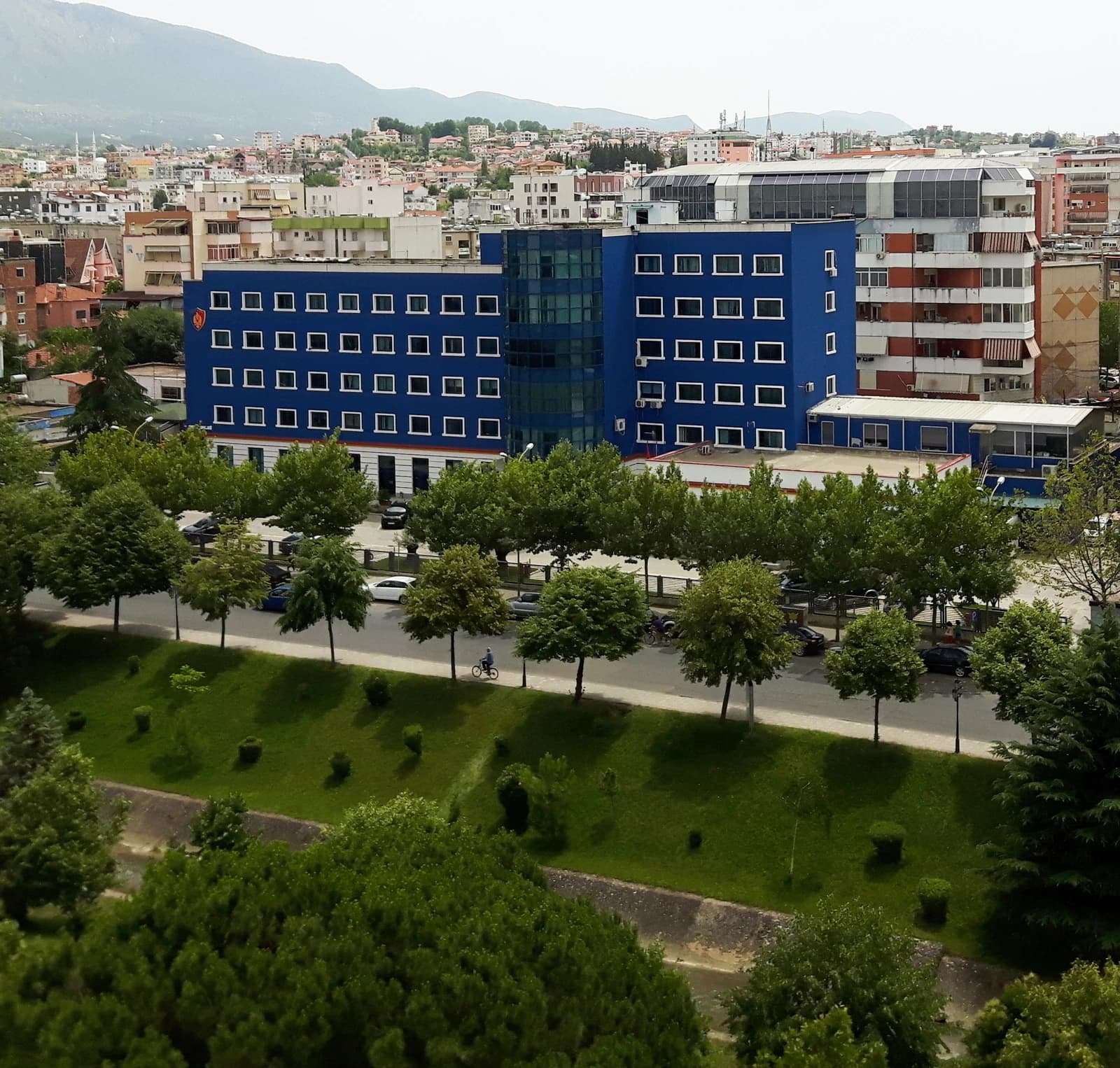 Exterior of the Albanian State Police Headquarters in Tiranë, a blue building with many windows.