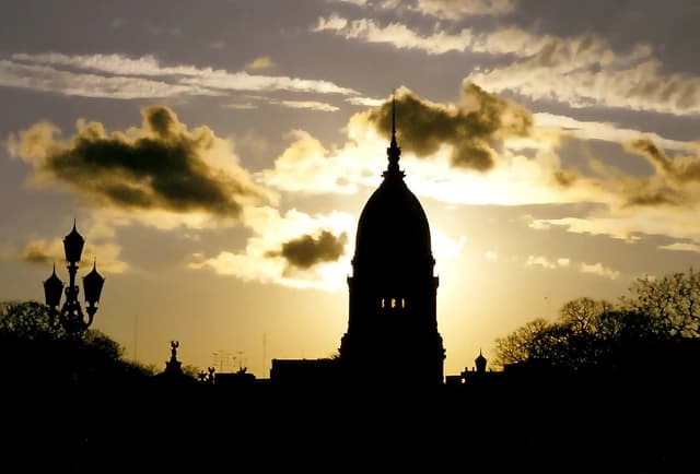 Congress building dome in Buenos Aires silhouetted against a cloudy sunset sky.