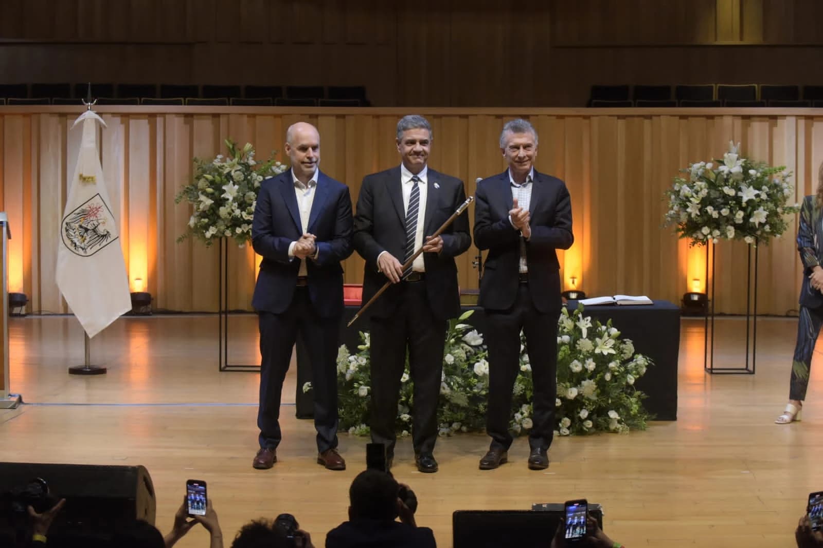 Jorge Macri, surrounded by other politicians, standing on a stage.