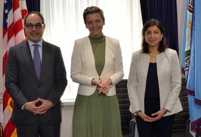 Jonathan Kanter, Margrethe Vestager, and Lina Khan standing side by side indoors.