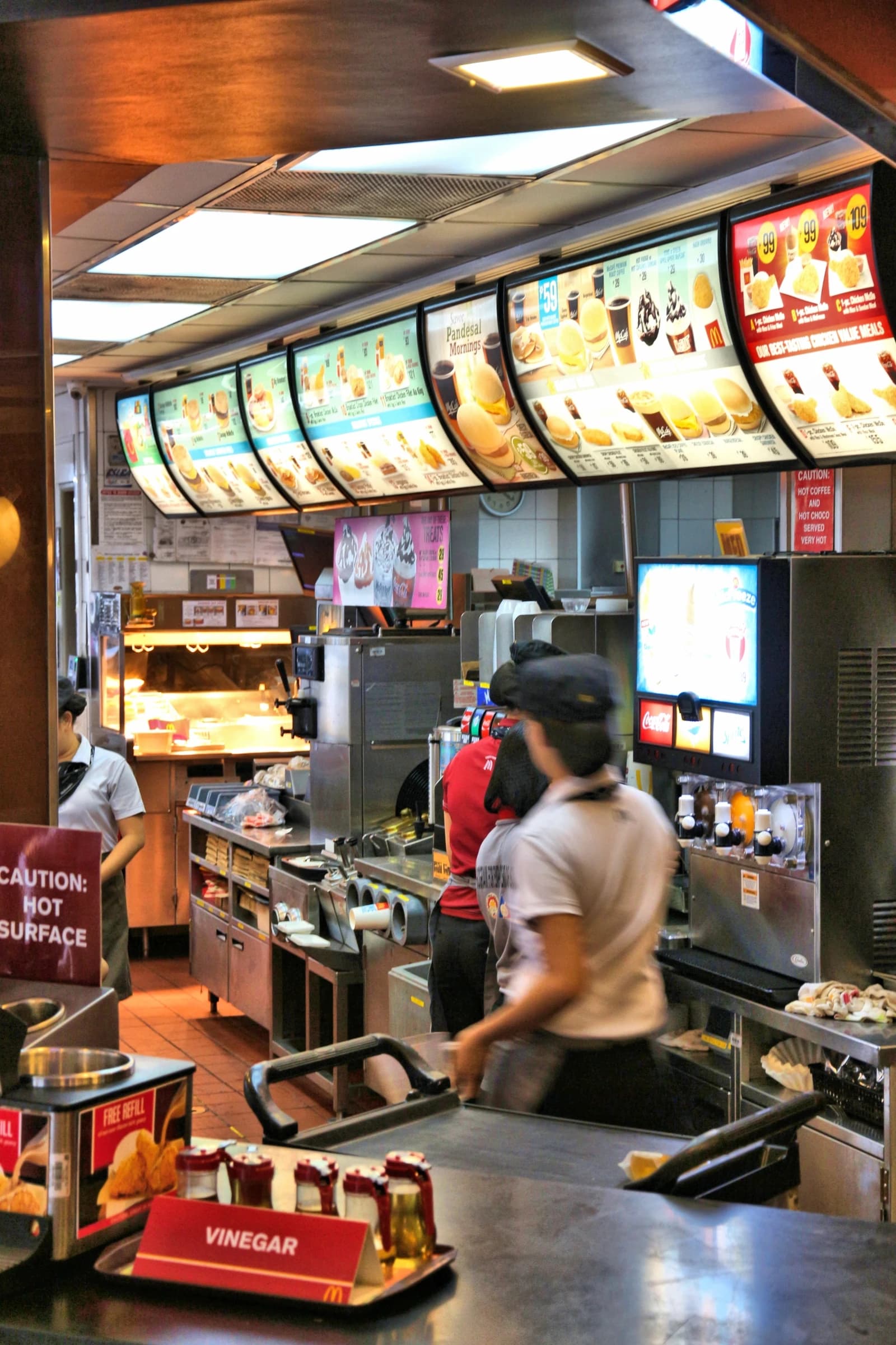 McDonald's restaurant interior in Manila, Philippines, with employees behind the counter.