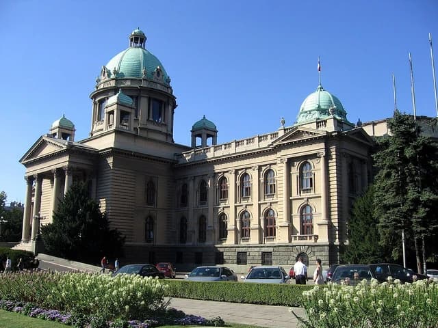National Assembly of Serbia building in Belgrade, with green domes and classical architecture.