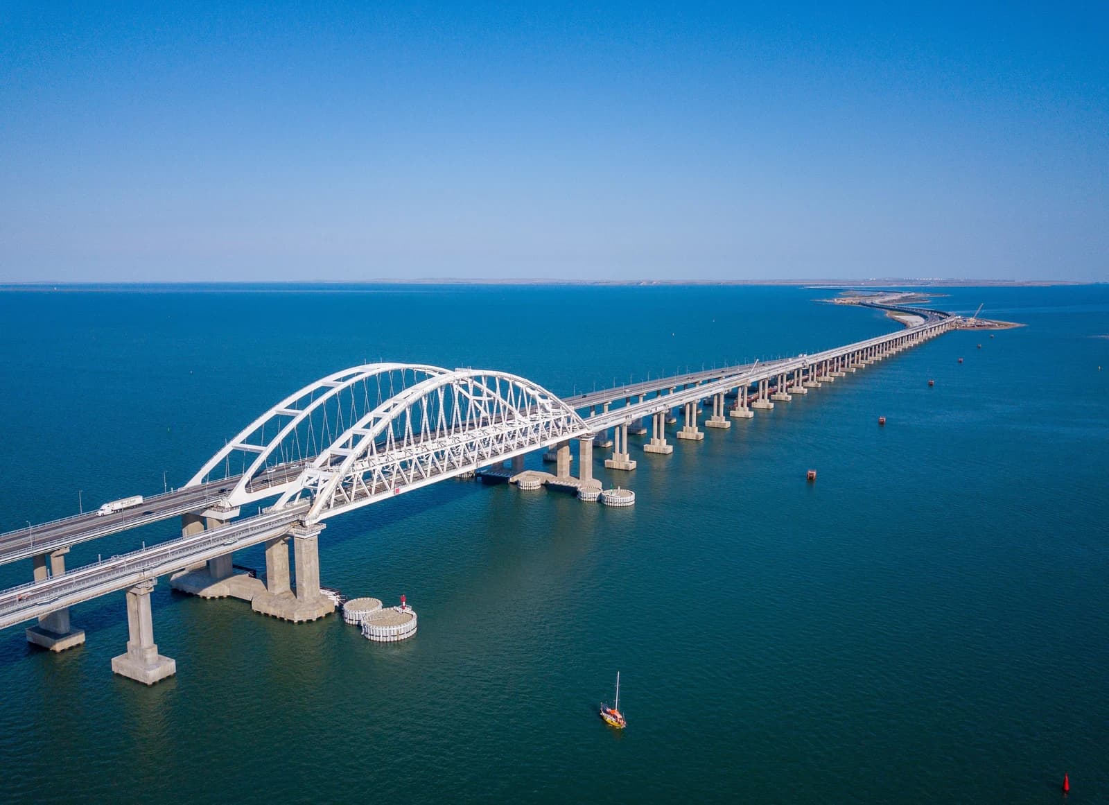 Aerial view of the Crimean Bridge spanning across a wide body of blue water.