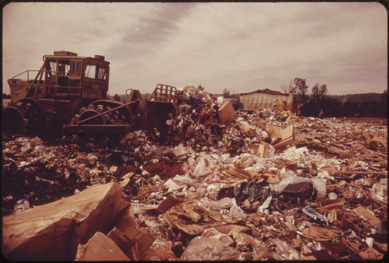 Landfill in Portland, Oregon, with waste compactor and discarded materials.