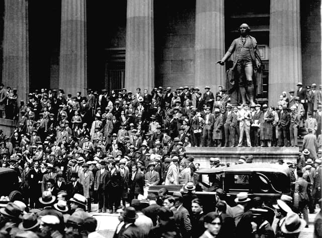 Crowd of men in suits and hats gathered outside the New York Stock Exchange.