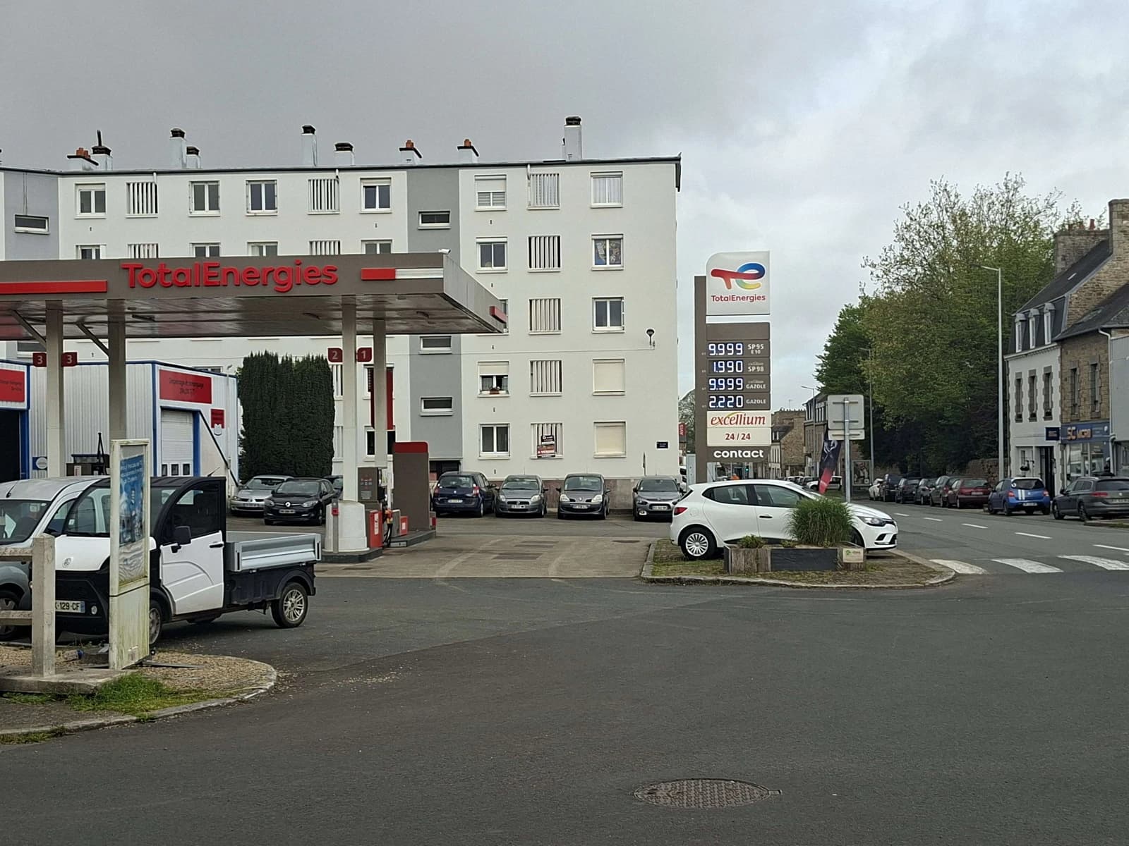 TotalEnergies gas station in France with several vehicles parked and fuel price display.