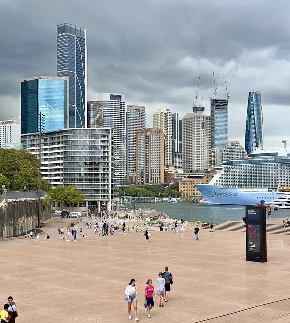 Skyscrapers and a large cruise ship docked in the Sydney Central Business District.