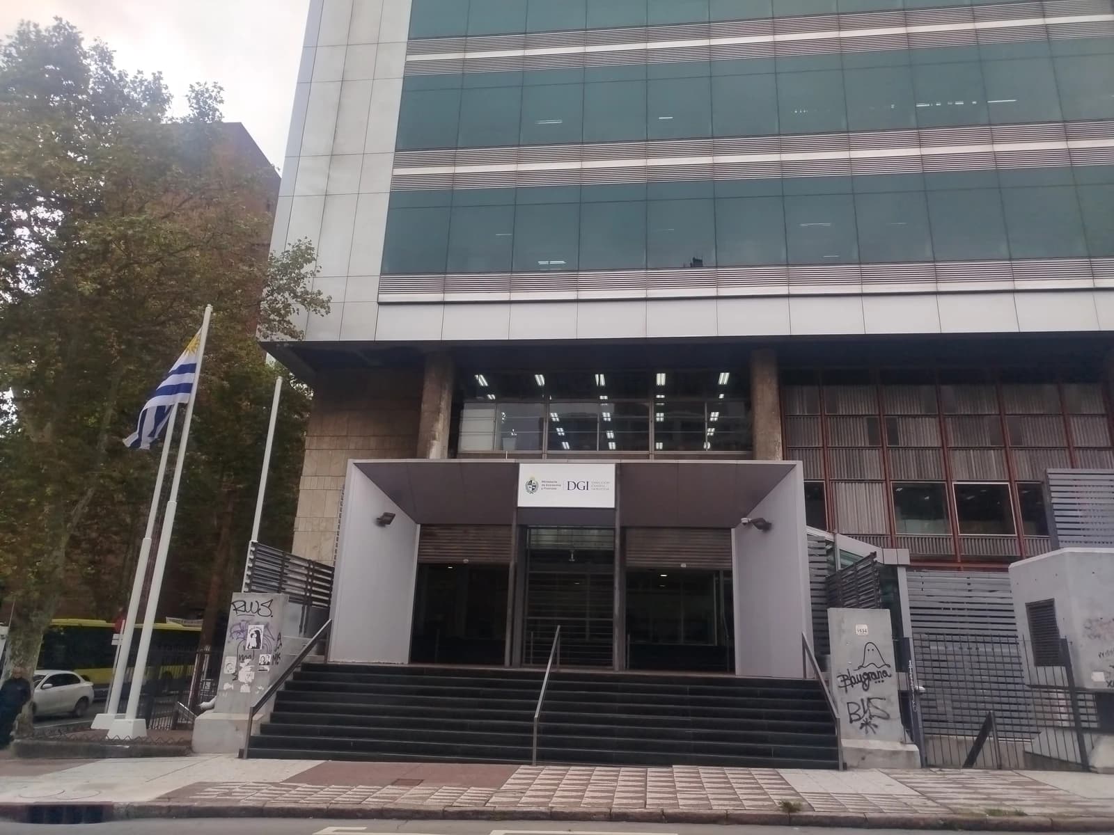 Exterior of the Dirección General Impositiva del Uruguay building with the national flag flying.