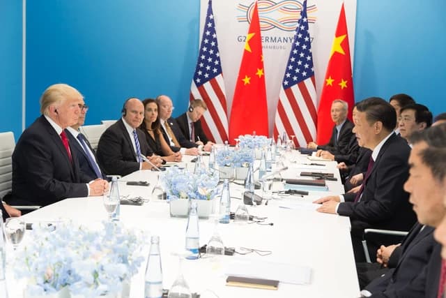 President Donald Trump and President Xi Jinping seated at a long table with delegations.