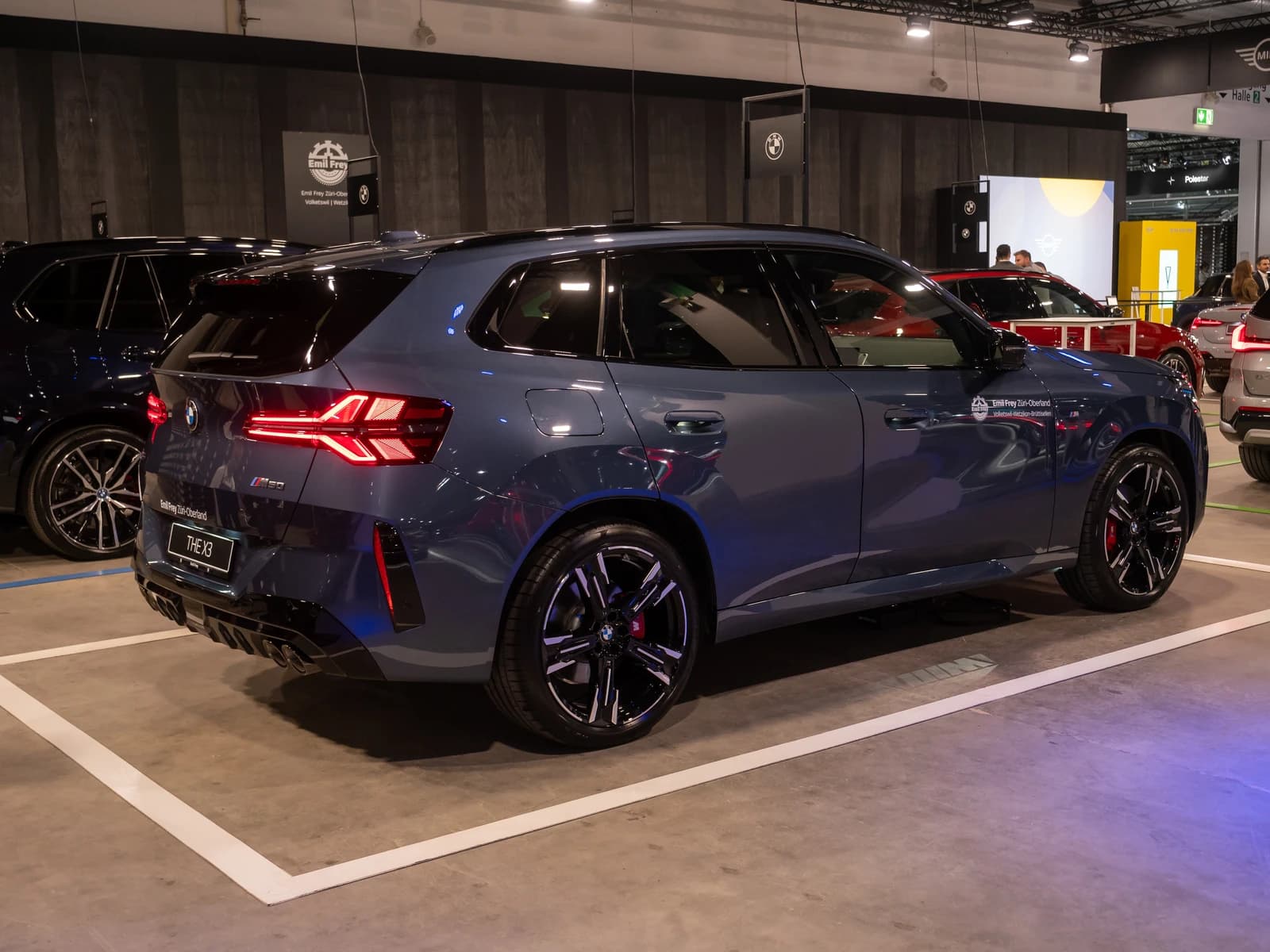 Blue BMW iX3 SUV shown at an auto exhibition in Zurich, Switzerland.